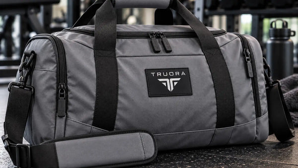 Gray truora duffel bag with black straps and zippers, featuring a sleek, durable design ideal for gym or travel use.
